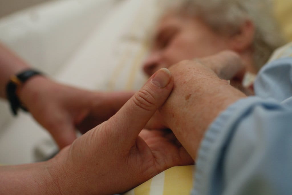 Hand halten einer bettlägerigen Frau