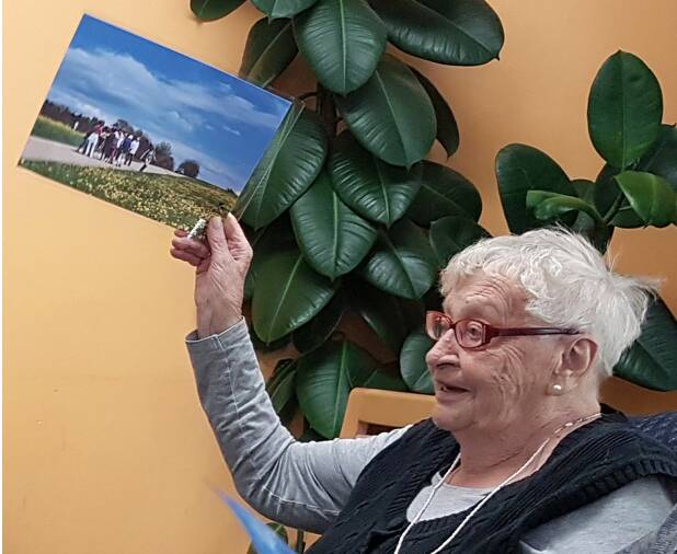 Seniorin hält Foto hoch