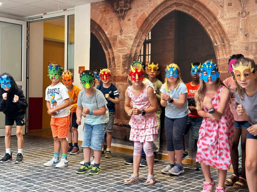 Die Dinos kommen: Mit farbenfrohen, fantasievollen Masken und viel Temperament zelebrierten die Grundschüler beim Dino-Tanz Freude an Bewegung pur.