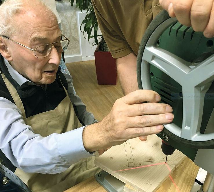 Senior beim Holzwerken