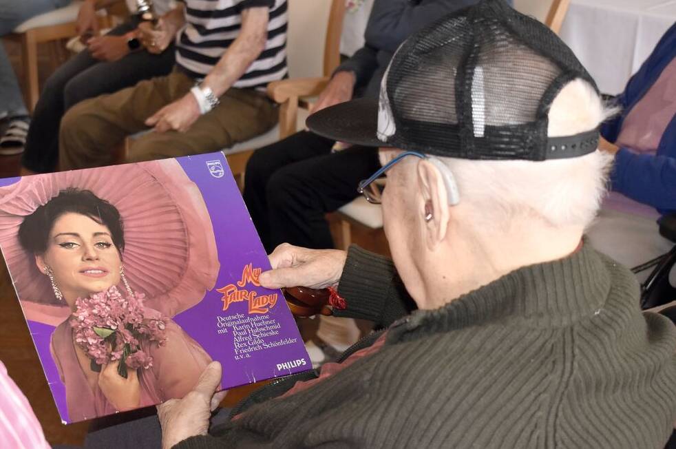Senior betrachtet Plattencover