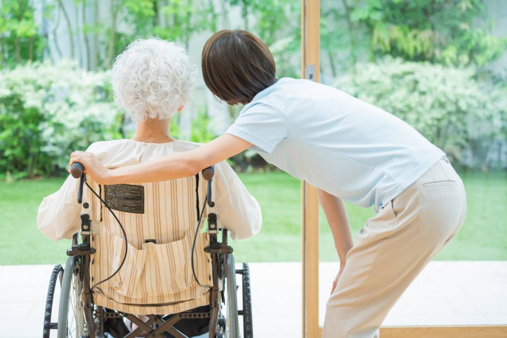 Seniorin im Rollstuhl mit Betreuuerin
