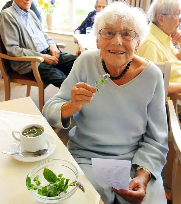 Seniorin trinkt frischen Kräutertee
