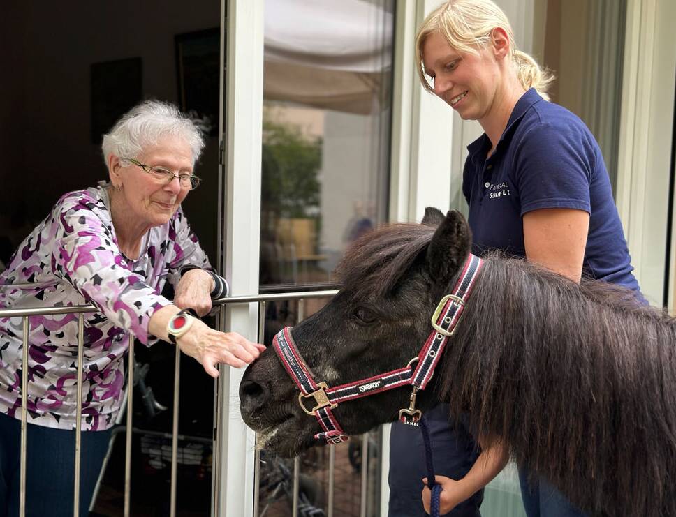 Bewohnerin streichelt Pony