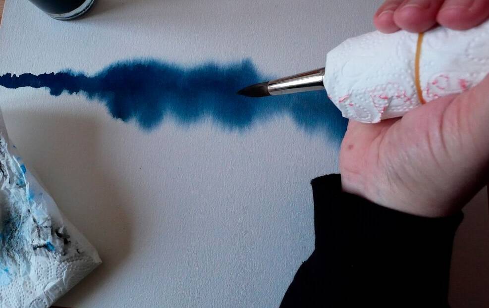 Hand umschließt Pinsel