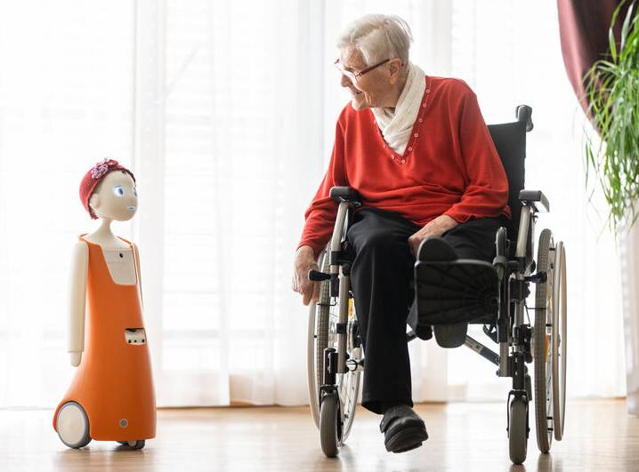 Sozialer Roboter mit einer Seniorin im Gespräch