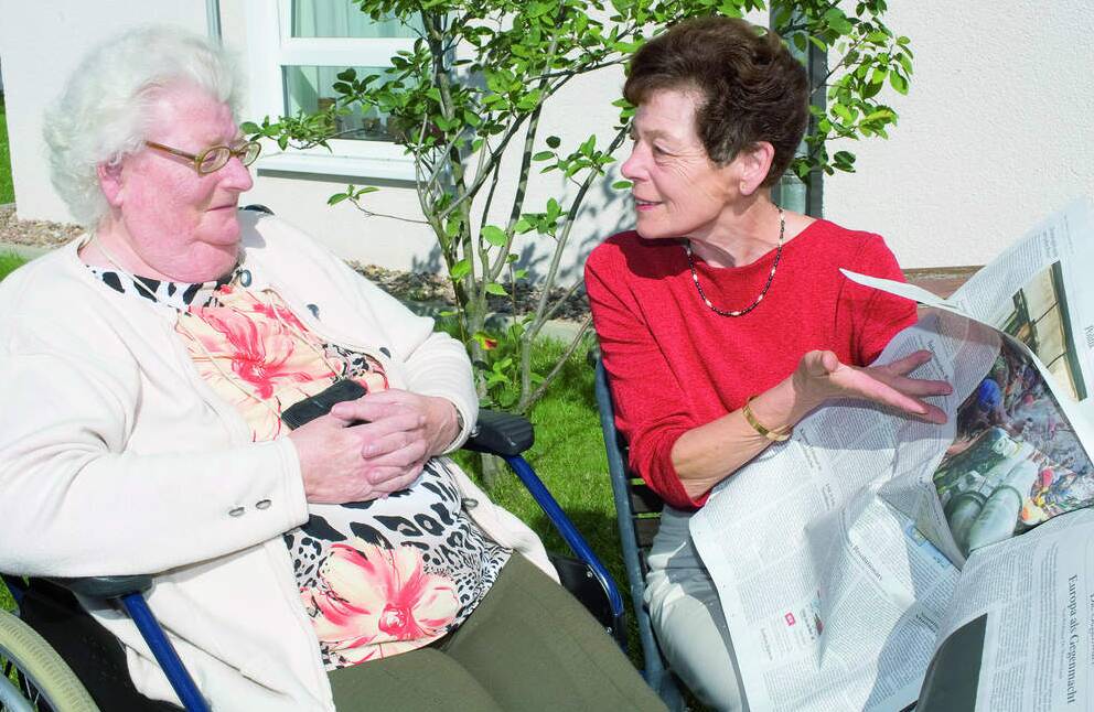 gemeinsame Zeitungslektüre jüngerer und älterer Frau