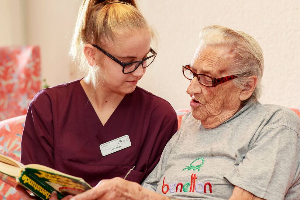Junge Frau liest Senior vor