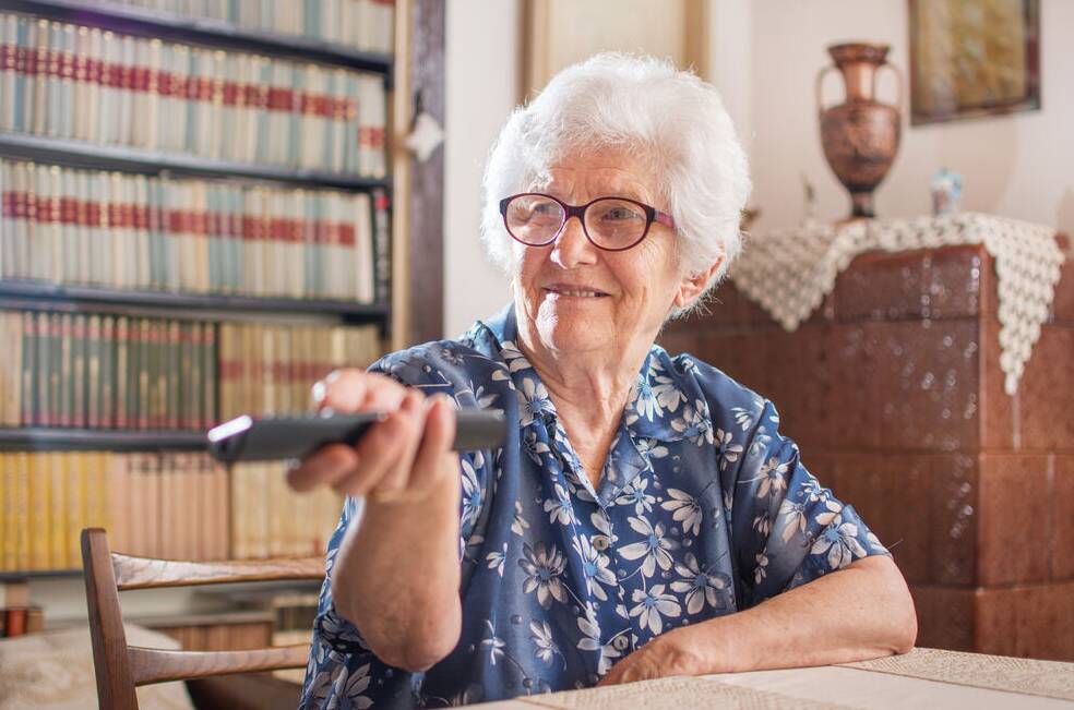 Seniorin wählt Fernsehprogramm