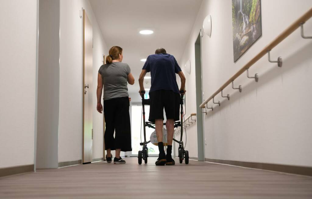 Mann am Rollator begleitet