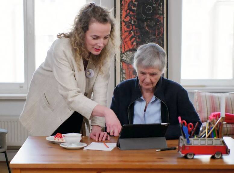 Betreuerin und Seniorin am Tablet