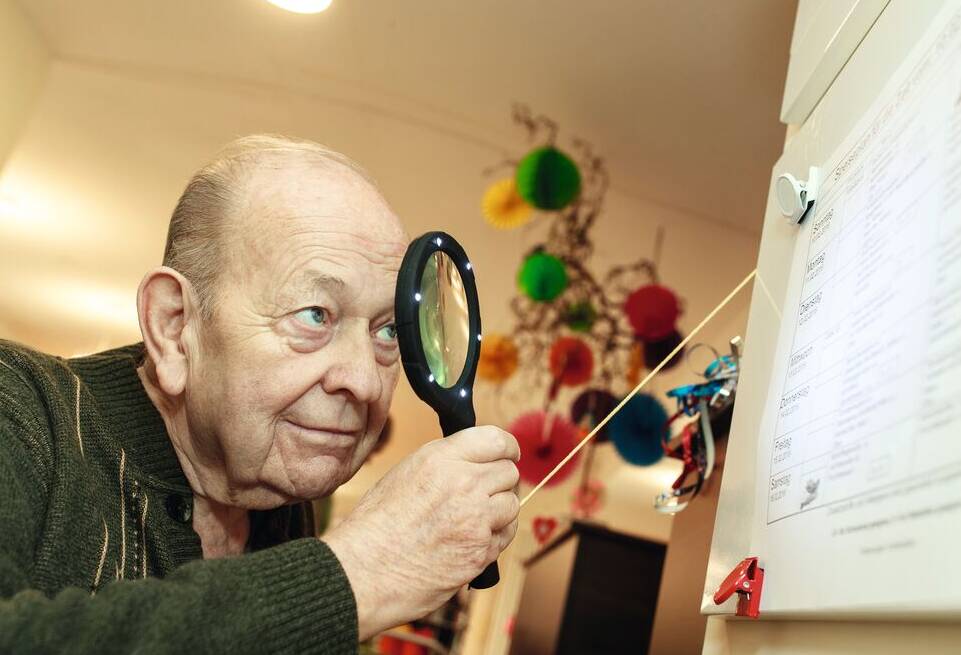 Senior liest mit Lupe
