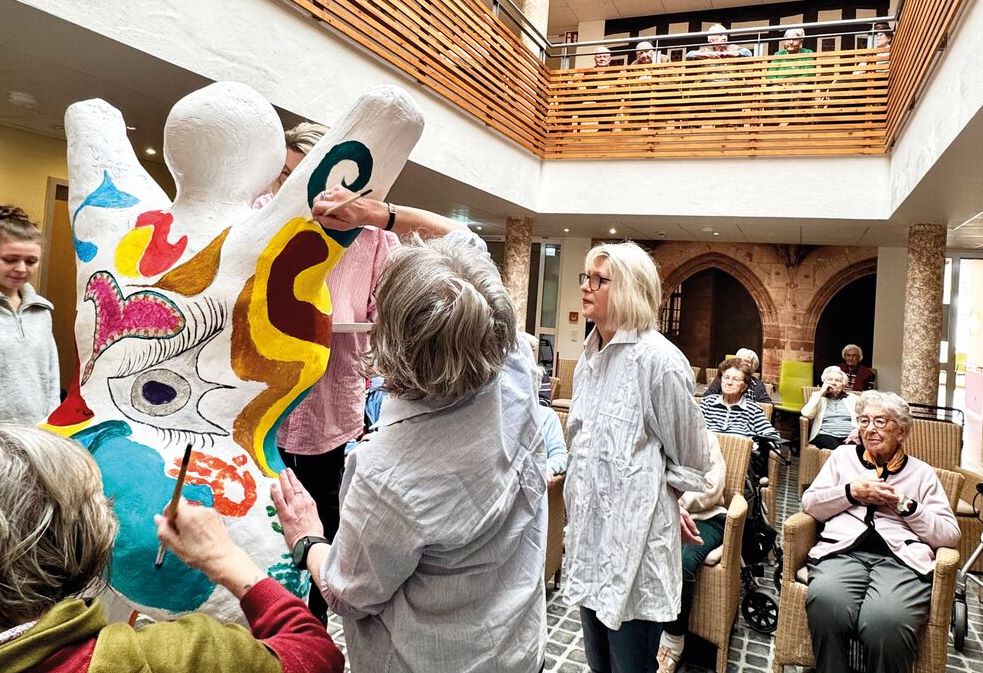 Bewohnerinnnen gestalten eine bunte Skulptur.