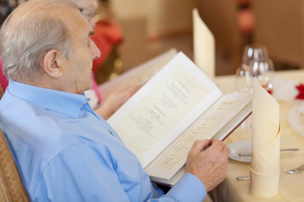 Senior studiert Speisekarte