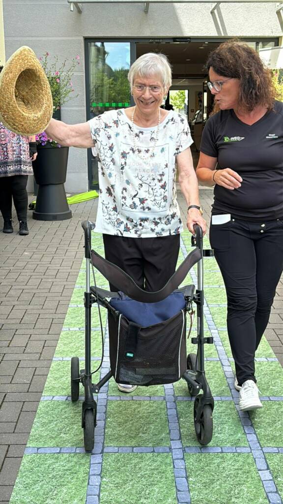 Bewohnerin mit Rollator auf dem G-Weg
