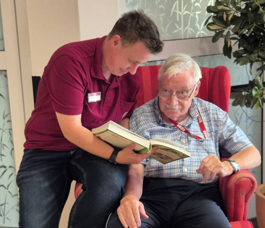 junger Mann liest Senior vor