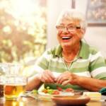 glückliche Seniorin beim Essen