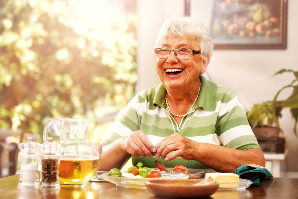glückliche Seniorin beim Essen